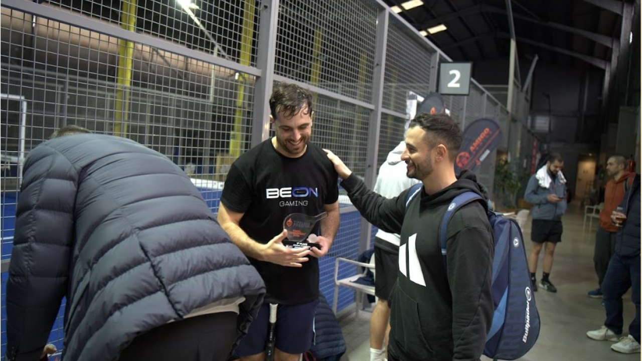 Um jogador recebe seu troféu após a partida durante o Torneio de Pádel Timeless Passion, em um ambiente próximo e descontraído